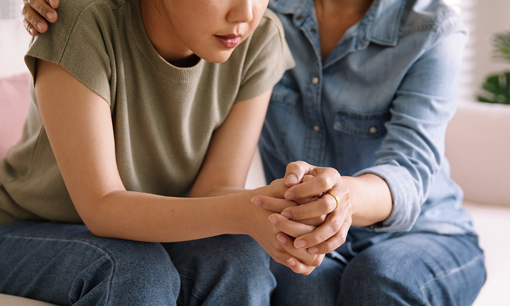 A photo of a woman offering support to another